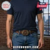 Rush Starman 1968 embossed leather belt featuring a circular brass buckle worn by a man in a navy t-shirt and blue jeans.