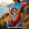 San Francisco 49ers x Grateful Dead Mascot Shirt with red, yellow, and blue tie-dye pattern on a person outdoors.