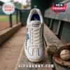 Skechers Los Angeles Dodgers D'Lites white sneakers featuring blue team graphics resting on a weathered wooden dugout bench.