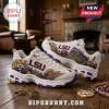 Skechers LSU Tigers D'Lites White Athletic Sneakers featuring purple and gold Tiger graphics on a rustic wooden floor.
