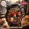 Sophia's Brew House Witch Sisters Ceramic Cauldron Mug featuring three cartoon witches inside a black pot on a wooden table.