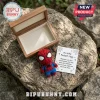 Spider-Man Felt Pocket Hug doll with a matching card in a small wooden box, sitting on a textured grey stone surface.