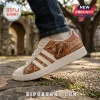 Texas Longhorns Burnt Orange leather sneakers with bull graphic, three white stripes, and Hook 'Em Horns text on side.