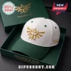 The Legend of Zelda Triforce Embroidered Cap in white and green with a gold Triforce logo inside a branded gift box.