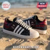 The Weeknd x Adidas After Hours Black Casual Sneakers featuring custom red and blue XO graphics on a sandy beach background.