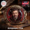Tim Curry In Loving Memory 1946-2026 ring with a portrait center, red stones, and bronze metal finish on an old book.