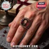 Tim Curry In Loving Memory 1946-2026 ring with a portrait framed in red enamel and metallic gold filigree on a hand.