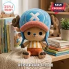 Tony Tony Chopper One Piece stuffed plush toy wearing a blue hat with an X emblem and yellow striped shirt on a bookshelf.