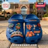 University of Florida Gators Blue Crocs With Charms featuring mascot, football helmet, and logo pins on a paved walkway.