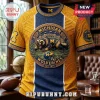 University of Michigan Wolverines NCAA mascot t-shirt featuring a central wolverine graphic, gold and navy blue pattern.