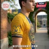 University of Michigan Wolverines NCAA mascot t-shirt in maize and blue with athletic block M logo and graphic print.