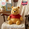 Winnie the Pooh Soft Plush Toy featuring golden yellow fur and a red knitted sweater sitting on a wooden nursery chair.