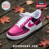 WNBA Team Breast Cancer Awareness Pink Nike Air Force 1 sneakers with ribbon patterns on a wooden surface with fall leaves.