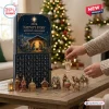 2026 Nativity Story Advent Calendar with blue box, gold ornaments, and a hand placing an angel on a wooden table.