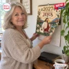Woman holding the 2027 A Year With Jesus Wall Calendar on a wall.