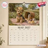 Wall calendar page for May 2027 featuring a Yorkshire Terrier with a scone on its head during a picnic.