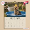 July 2027 wall calendar featuring a Yorkshire Terrier in a blue wading pool with a rubber duck.
