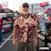 Front view of a man wearing a beige Arizona Cardinals For Life mascot Hawaiian shirt at a stadium tailgate party.