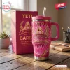 Front view of pink Barbie 67th Anniversary Stanley tumbler with matching gift box on a wooden desk.