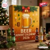 Front view of a Beer Advent Calendar 2026 box with a glass of beer illustration and assorted glass bottles on a table.