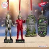 Front view of four hanging ornaments including two figures and two tombstones.