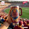 Hand holding Brisbane Lions 2024-2026 YETI Stanley Tumbler at a crowded stadium.