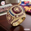 Closeup of Brisbane Lions AFL Gold Championship Ring featuring a red stone and lion emblem.