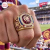 Closeup of Brisbane Lions AFL Gold Championship Ring on a hand at a stadium.