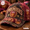 Closeup of the Brisbane Lions AFL Premiers Distressed Cap with embroidered team crest and frayed edges on wooden table.