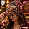 Close-up of a person wearing a maroon Brisbane Lions AFL Premiers distressed cap with frayed edges.