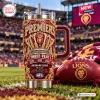 Front view of Brisbane Lions Three-Peat YETI Stanley Tumbler with maroon handle on a football field.