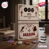 BTS Arirang World Tour 2026 Advent Calendar box featuring maroon graphics, hanging ornaments, and text on a wooden surface.