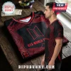 BTS World Tour 2026 Black Red Football Jersey featuring a geometric graphic pattern and V-neck design on a wooden table.