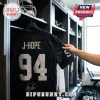 BTS x Las Vegas Raiders Custom Football Jersey in black with white text J-HOPE and number 94 displayed in a locker room.