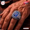 Closeup of a hand wearing a Buffalo Bills 66th Anniversary championship ring with a blue central stone.