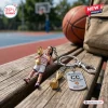 Keychain featuring a basketball player figure and metal tag on a wooden bench at a court.