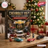 Chevrolet 115th Anniversary Advent Calendar 2026 featuring vintage and modern car models on a wooden table near a tree.