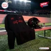 Black Cincinnati Bearcats City Within Red Hoodie on stadium bench with helmet.