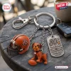 Closeup of Cleveland Browns 80th Anniversary Metal Keychain with helmet, bulldog, and dog tag pendants on a wooden table.