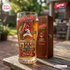 Front view of a 125th Anniversary Cleveland Indians beer glass next to a wooden box on a rustic outdoor table.
