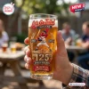 Hand holding a Cleveland Indians Chief Wahoo 125th Anniversary beer glass with sports graphics.