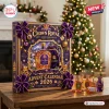 Front view of a purple Crown Royal 87th Anniversary Advent Calendar on a wooden table with mini bottles.