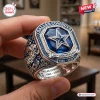 Closeup of a Dallas Cowboys 66th Anniversary silver commemorative ring with a large blue center stone and star emblem.