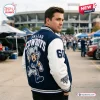 Back view of a person wearing the Dallas Cowboys Football Mascot Baseball Jacket in a parking lot.