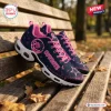 Side view of Dallas Cowboys x Breast Cancer Awareness Air Max Plus sneakers resting on a wooden park bench.