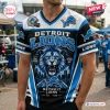 Front view of a blue, black, and white Detroit Lions football mascot t-shirt with a V-neck and city skyline graphic.