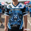 Front view of a Detroit Lions graphic t-shirt featuring a roaring lion mascot, skyline, and team text.