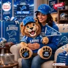 A smiling woman in a blue hat holding a Detroit Lions mascot crocheted plush doll with a team pennant and jersey.