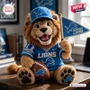 Front view of a Detroit Lions mascot crocheted plush doll wearing a blue team jersey, cap, and holding a small pennant.