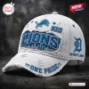 Side angle view of a white distressed Detroit Lions One Pride baseball cap featuring blue team logos and city skyline art.
